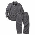 Mann trägt graues Leinen-Set mit Langarmhemd und Hose, aufgerollte Ärmel, entspannter Sommerauftritt