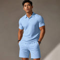 Poloshirt und Shorts Set in Schwarz und Hellblau von vorne — Polokragen mit Knopfleiste, mittlere Beinlänge