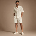 Mann trägt beiges Rippstrick-Set mit offenem Camp-Kragen und passender Shorts, entspannte Sommerstimmung